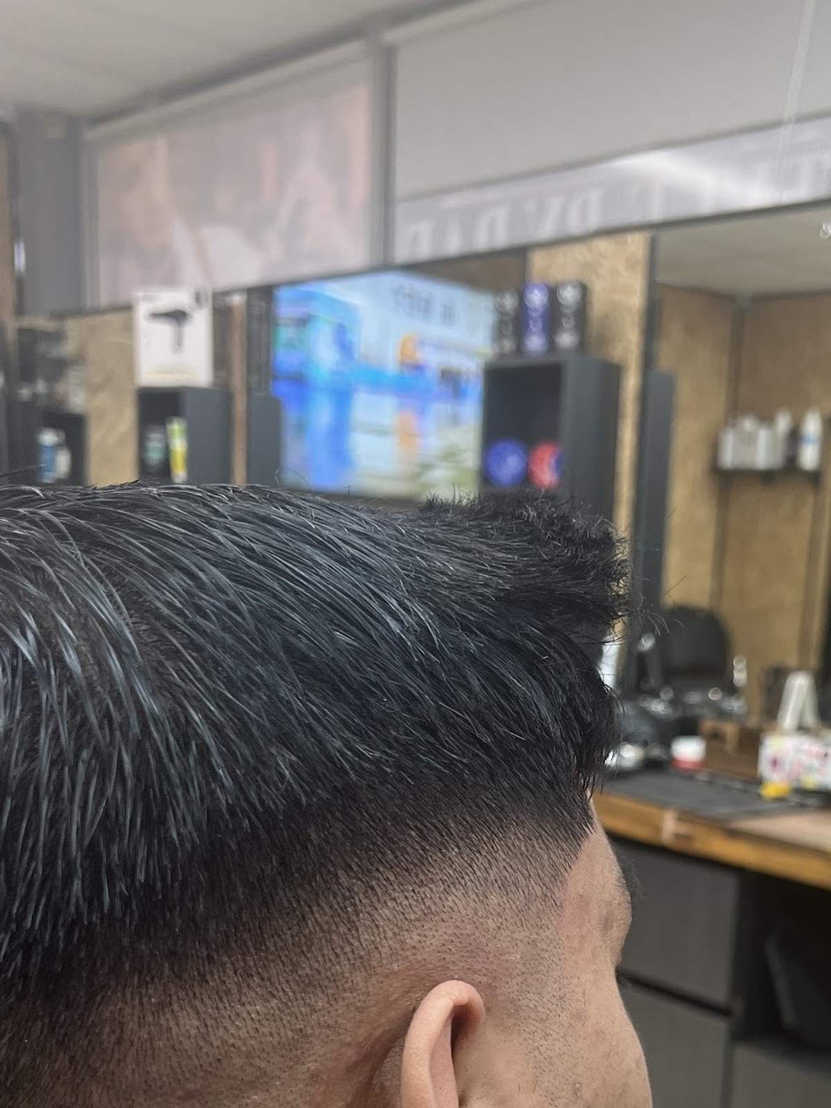 Fresh skin fade haircut at Style by Raf in Stanmore, with the barber's station in the background